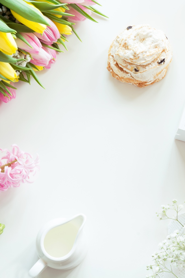 Букет тюльпанов и гиацинт на столе с пирожным и чашкой какао 