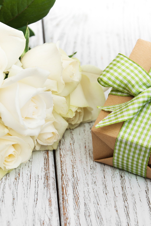 Букет белых роз на столе с подарком