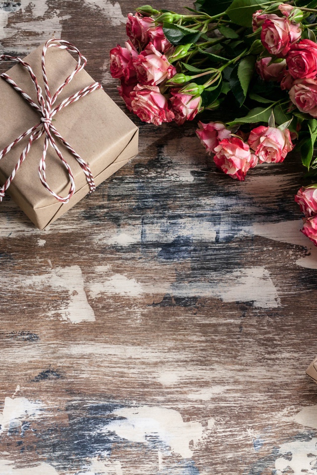 Подарочные коробки на деревянной поверхности с букетом роз