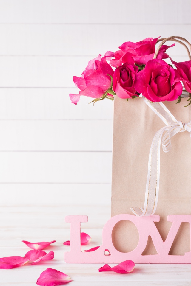Пакет с розами на столе с надписью Love