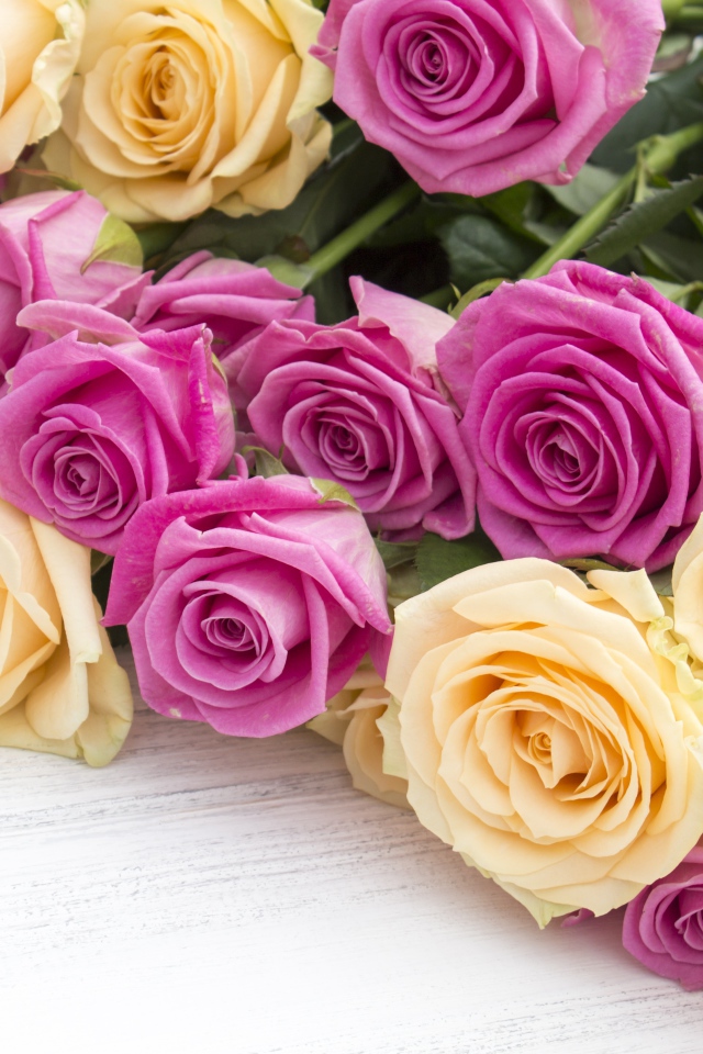 Розовые и белые розы на белом столе 