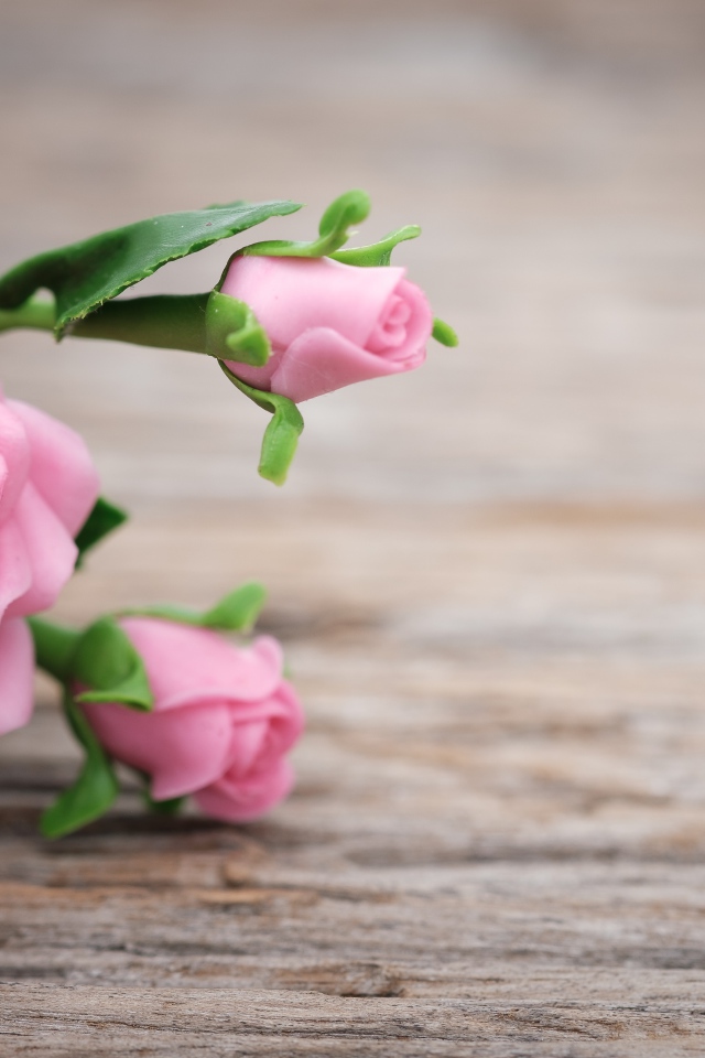 Розовые искусственные розы с сердцем на деревянном фоне