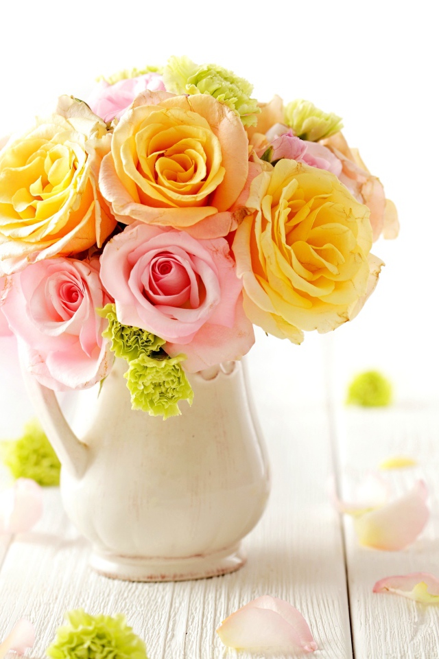 Желтые и розовые розы в вазе на столе 