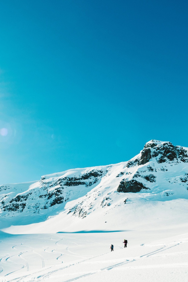 Красивые заснеженные горы под голубым небом в лучах солнца 
