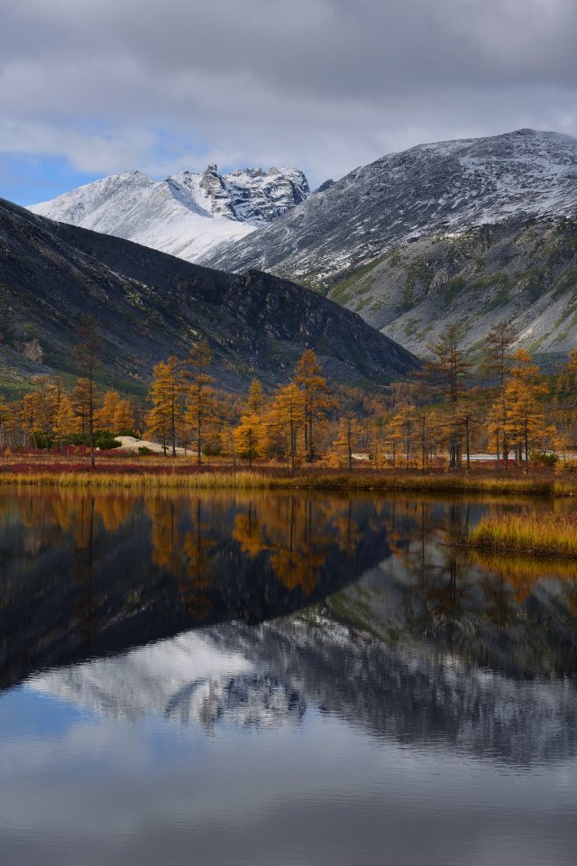 Горы отражаются в глади воды озера осенью