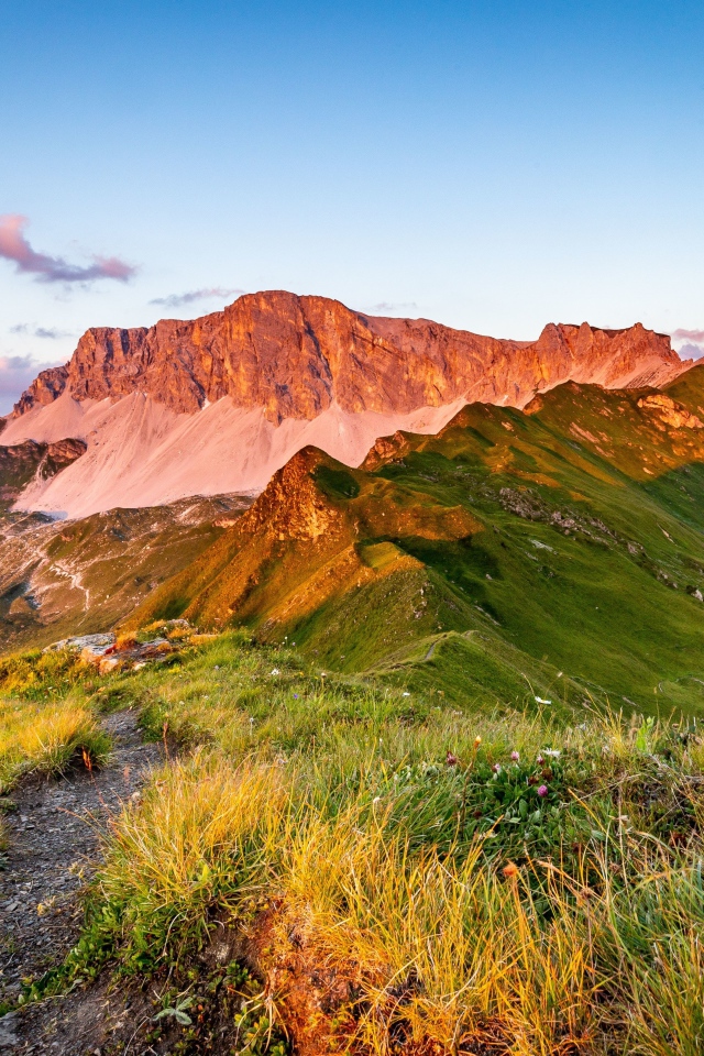 Солнце встает над зелеными горами