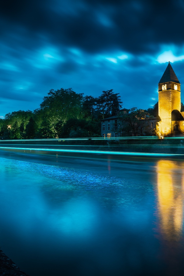 Башня на берегу реки ночью 