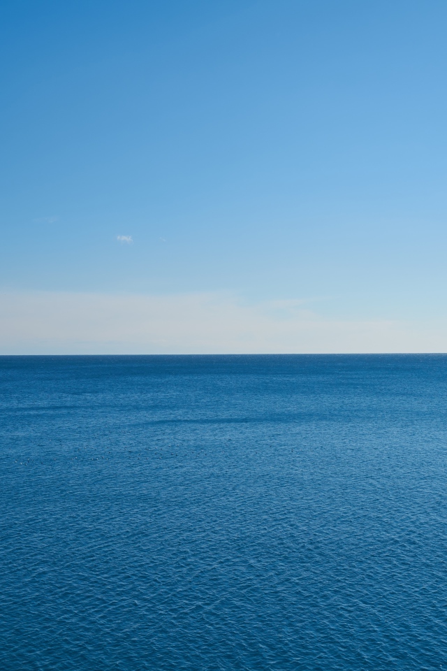 Calm sea water against a blue sky