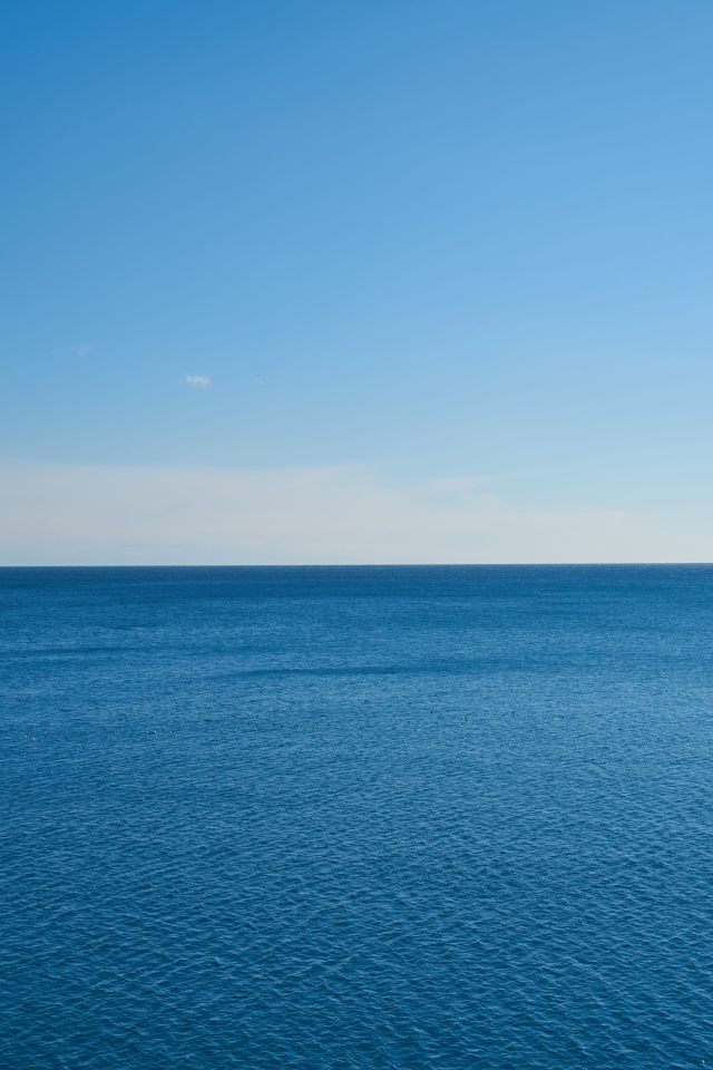 Спокойная морская вода на фоне голубого неба 