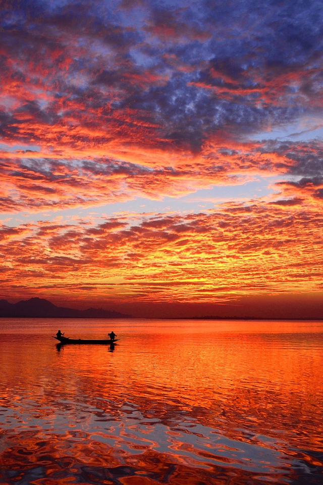 Boat on the water of a calm lake at sunset