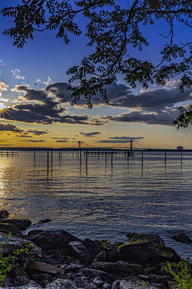 Солнце садится за тучи на горизонте в море