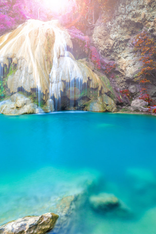 Водопад стекает по скале в голубую воду, Тайланд