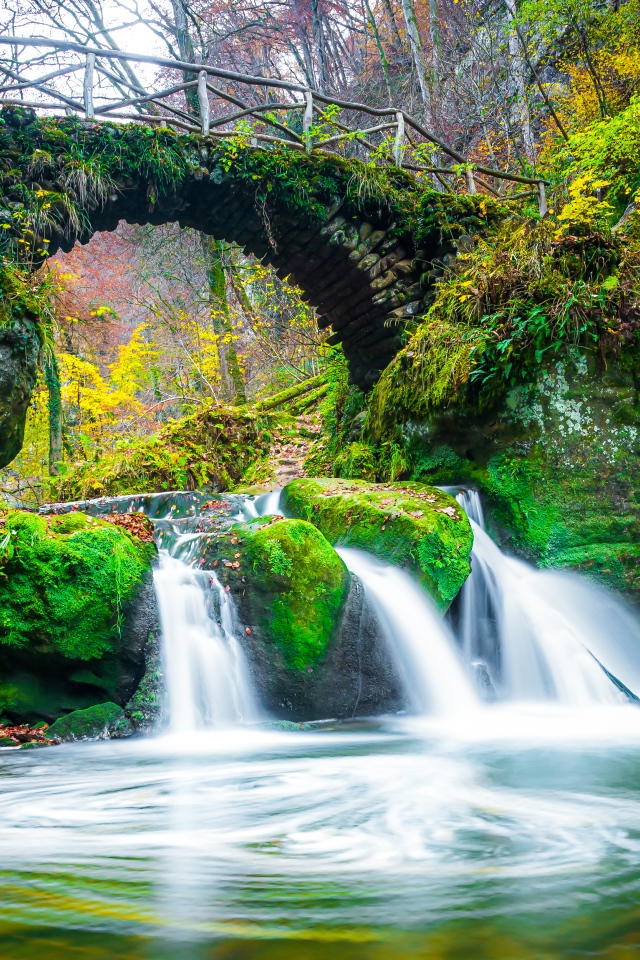 Водопад под старым покрытым мхом мостом