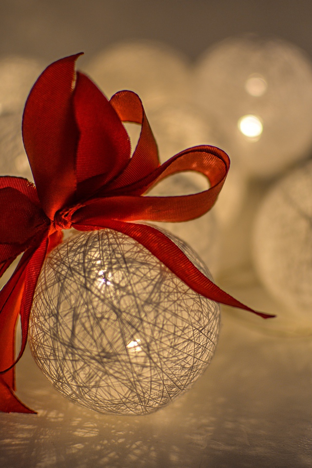 Красивый елочный шар с белых нитей с красным бантом