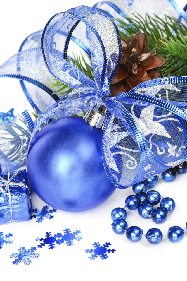 Красивый синий елочный шар с лентой на белом фоне с елочной веткой