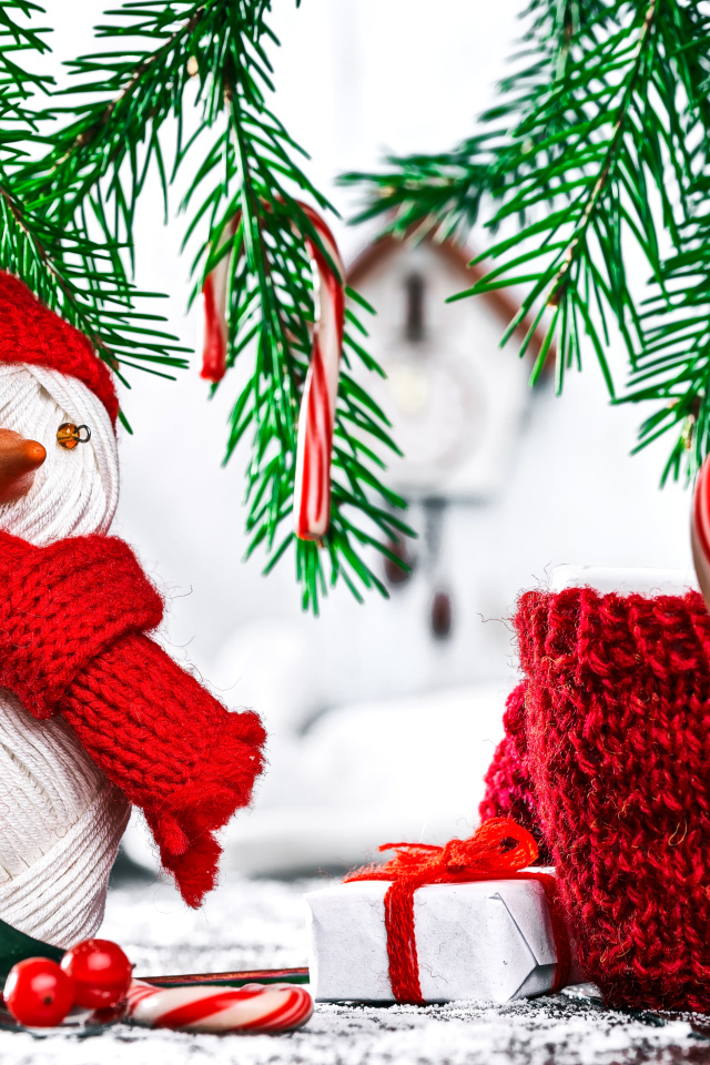 Снеговик из ниток на столе с чашкой и елочными ветками