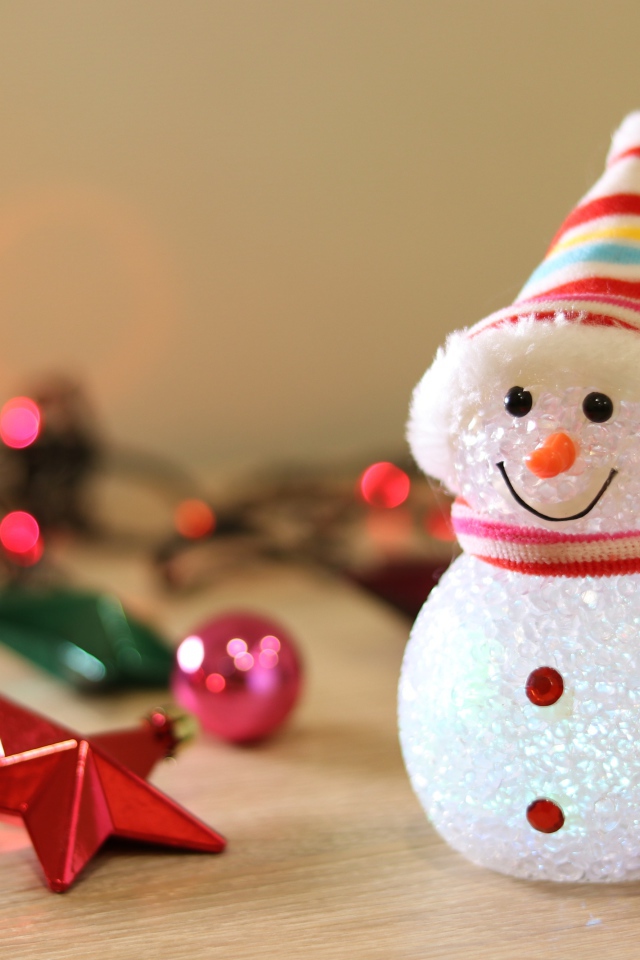 Снеговик с новогодними игрушками на столе