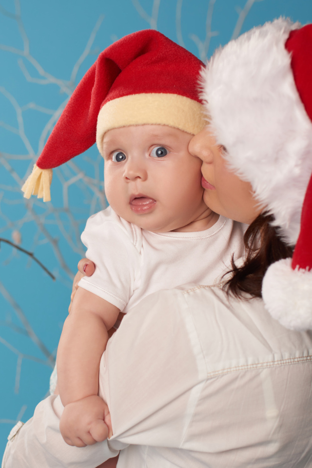 Маленький ребенок в новогоднем костюме на руках у мамы