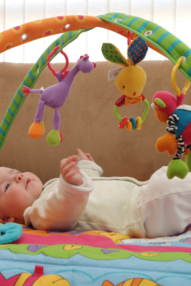 Грудной малыш играет с игрушками