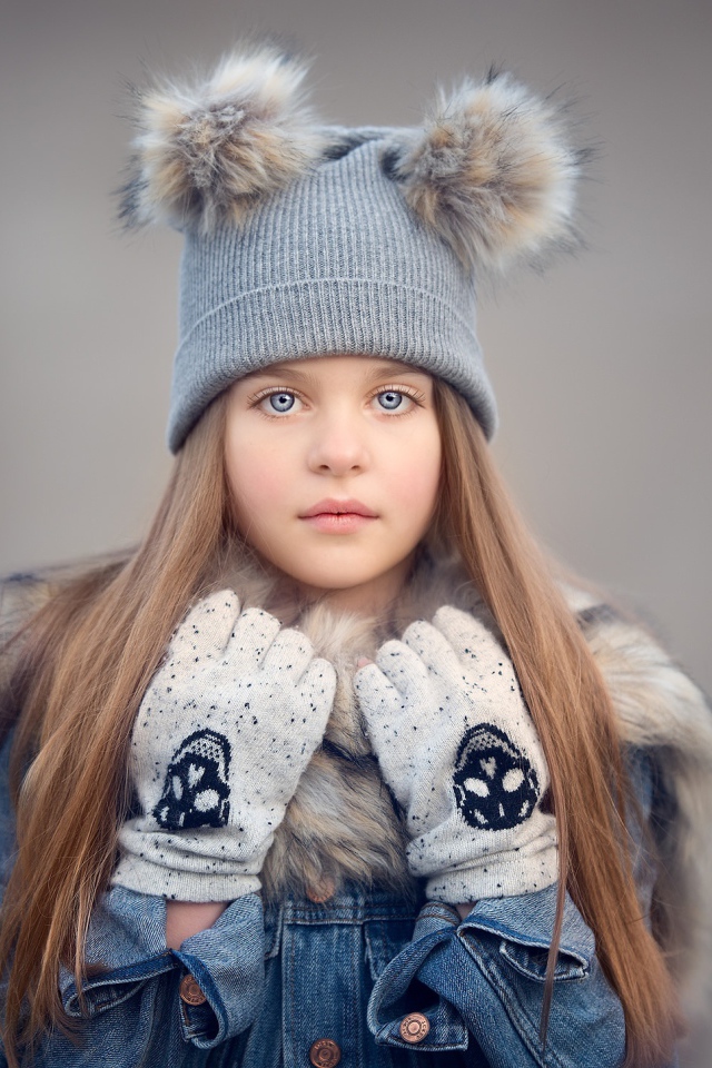 Красивая голубоглазая девочка в теплой шапке