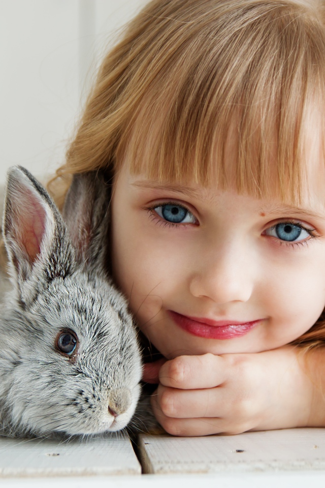 Красивая голубоглазая девочка с серым кроликом