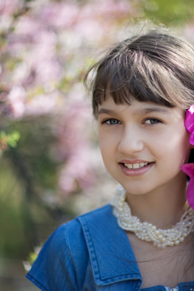 Красивая девочка с розовыми цветами в волосах