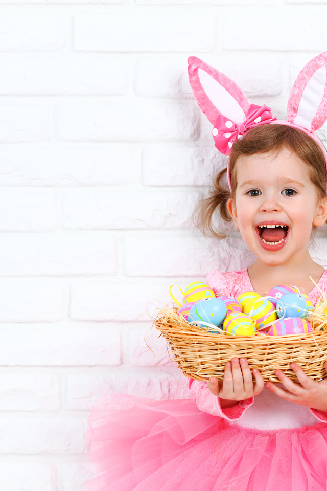 Красивая маленькая девочка в костюме с корзиной крашеных яиц 