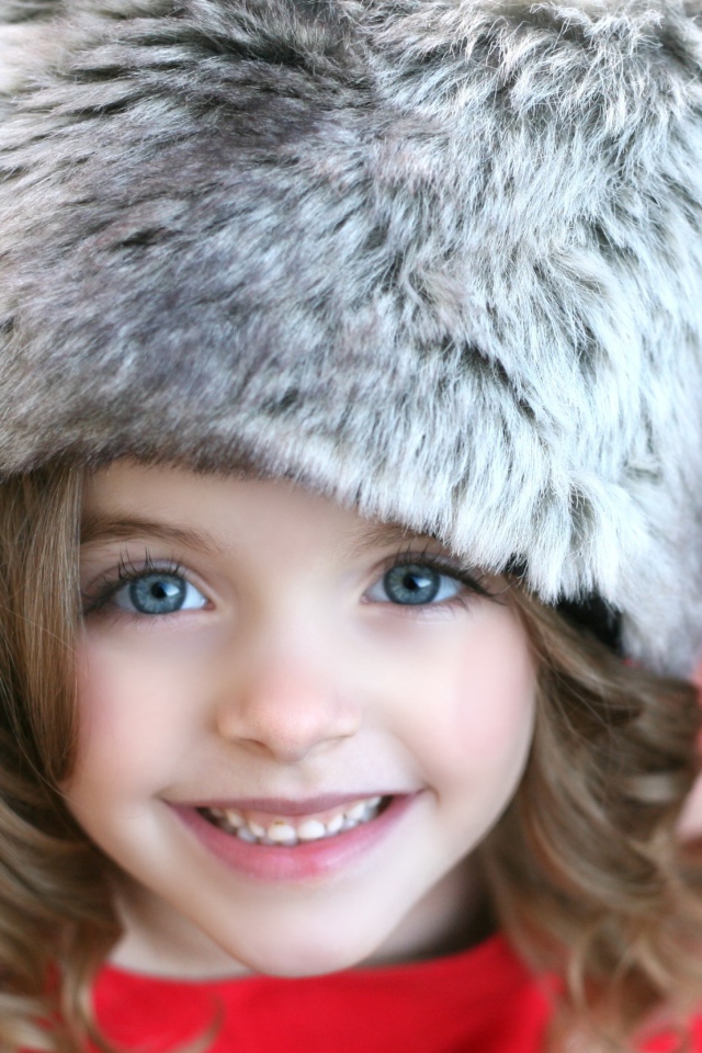 Красивая улыбающаяся девочка в меховой шапке