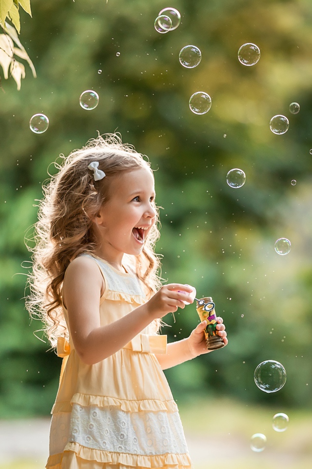 Веселая девочка с мыльными пузырями