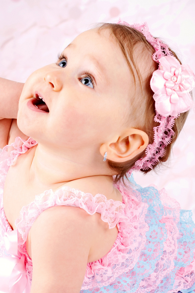 Милая голубоглазая девочка с розовой повязкой на голове