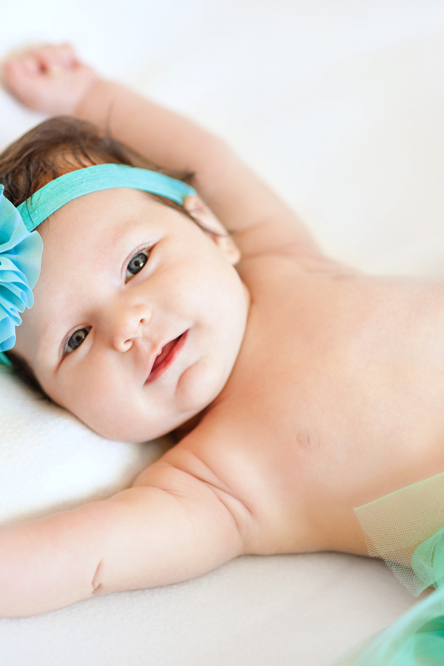 Милая маленькая девочка с повязкой с голубым цветком