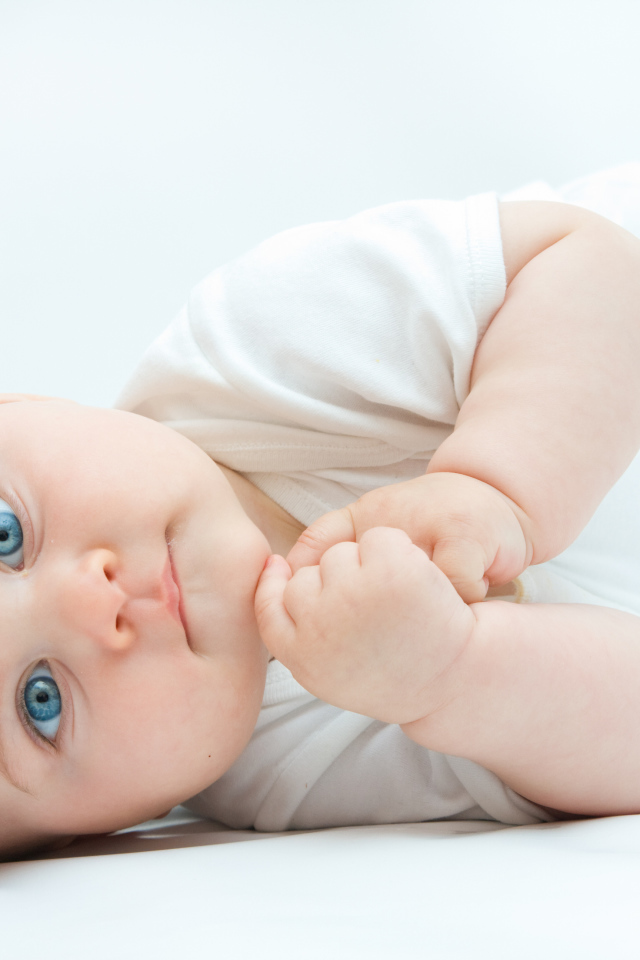 Забавный голубоглазый малыш на белом фоне