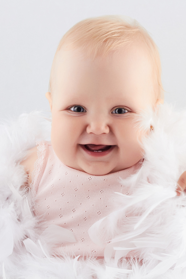 Смеющаяся маленькая девочка с перьями