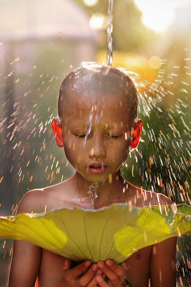 Маленький мальчик азиат умывается водой