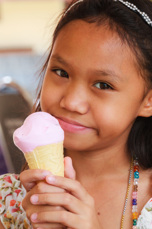 Маленькая девочка азиатка с мороженым в руке