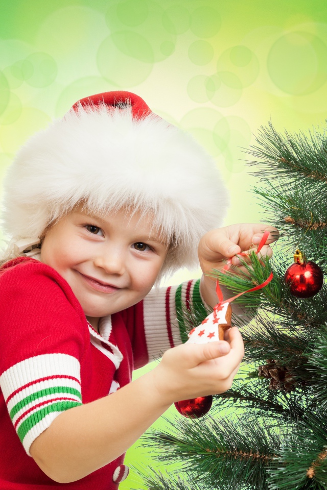 Маленькая красивая девочка наряжает елку на новый год