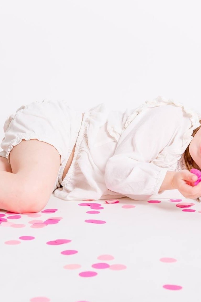 Маленькая голубоглазая девочка лежит на полу