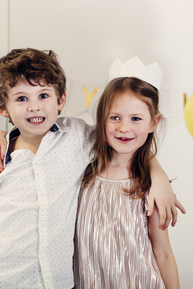 Маленькие мальчик и девочка на празднике с воздушными шарами