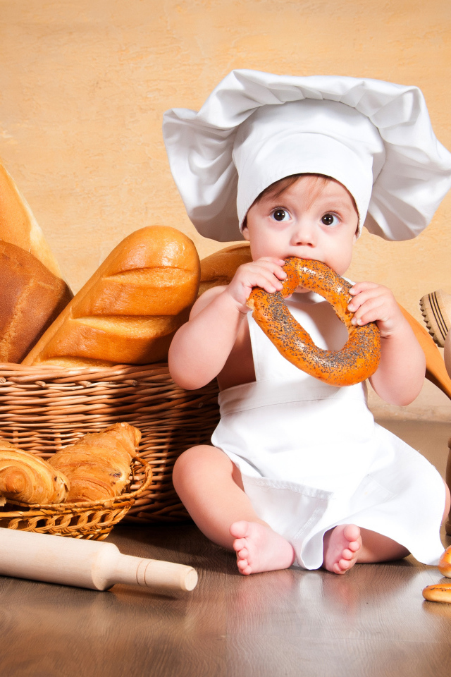 Маленький мальчик с хлебобулочными изделиями на столе 