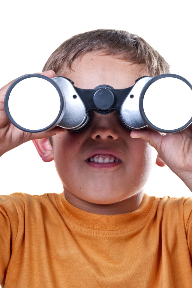 Маленький мальчик с биноклем на белом фоне
