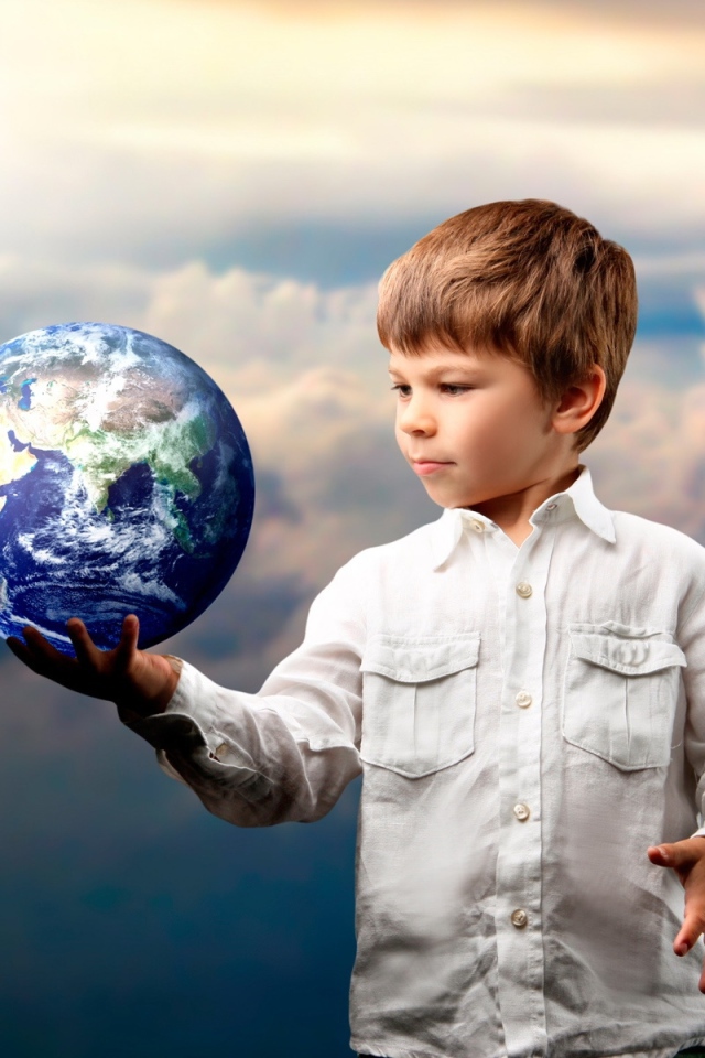 Маленький мальчик с планетой земля в руке