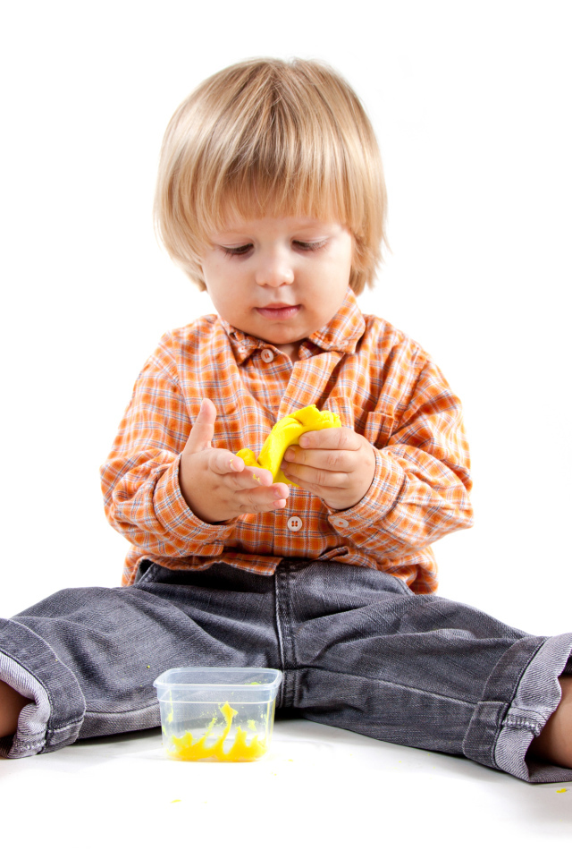 Маленький мальчик с игрушкой на белом фоне