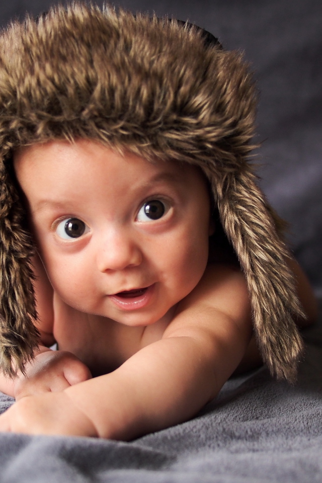 Маленький кареглазый ребенок в теплой шапке