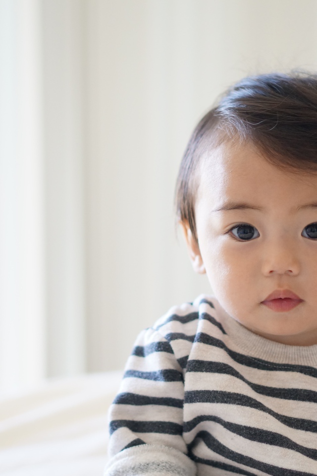 Маленький кареглазый мальчик в полосатом свитере