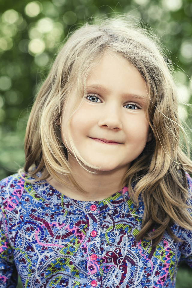 Маленькая милая голубоглазая девочка на качели