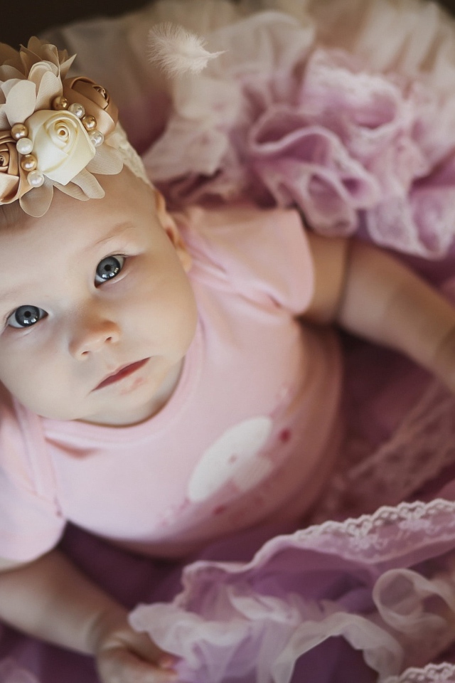 Маленькая милая девочка в пышном платье с повязкой на голове