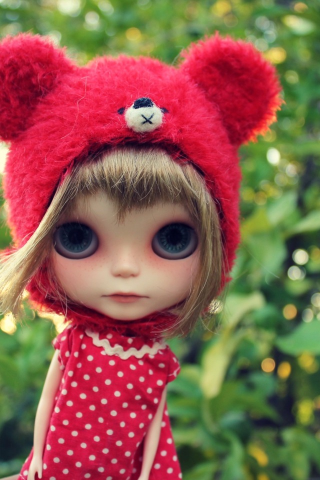 Маленькая кукла с большими глазами в красной шапке