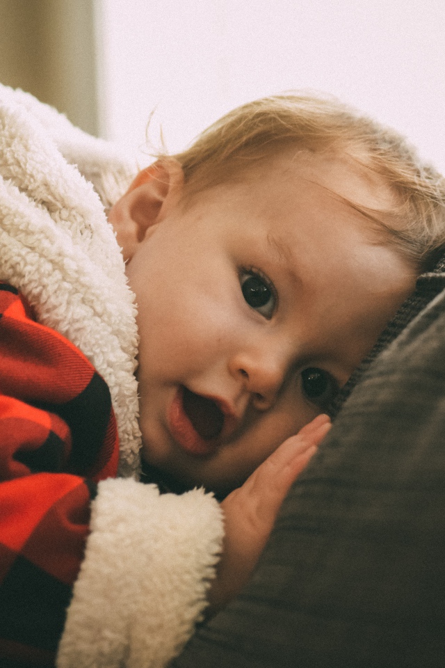 Маленький забавный малыш лежит на диване