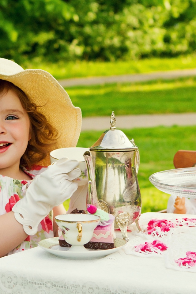 Маленькая девочка пьет чай на природе