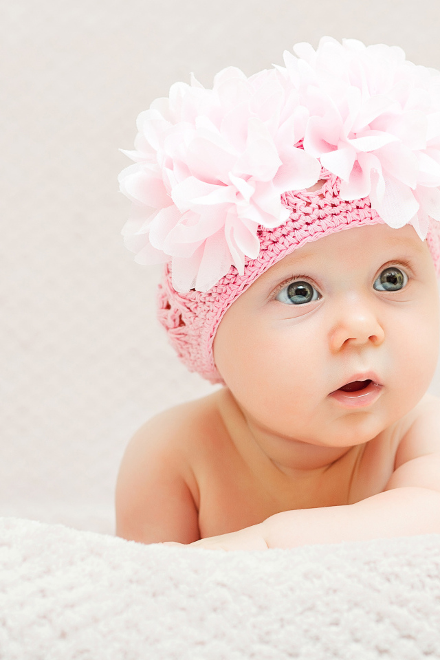 Маленькая девочка в вязаной шапке с цветами